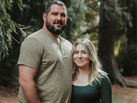 Couple posing for a photo together in a forest